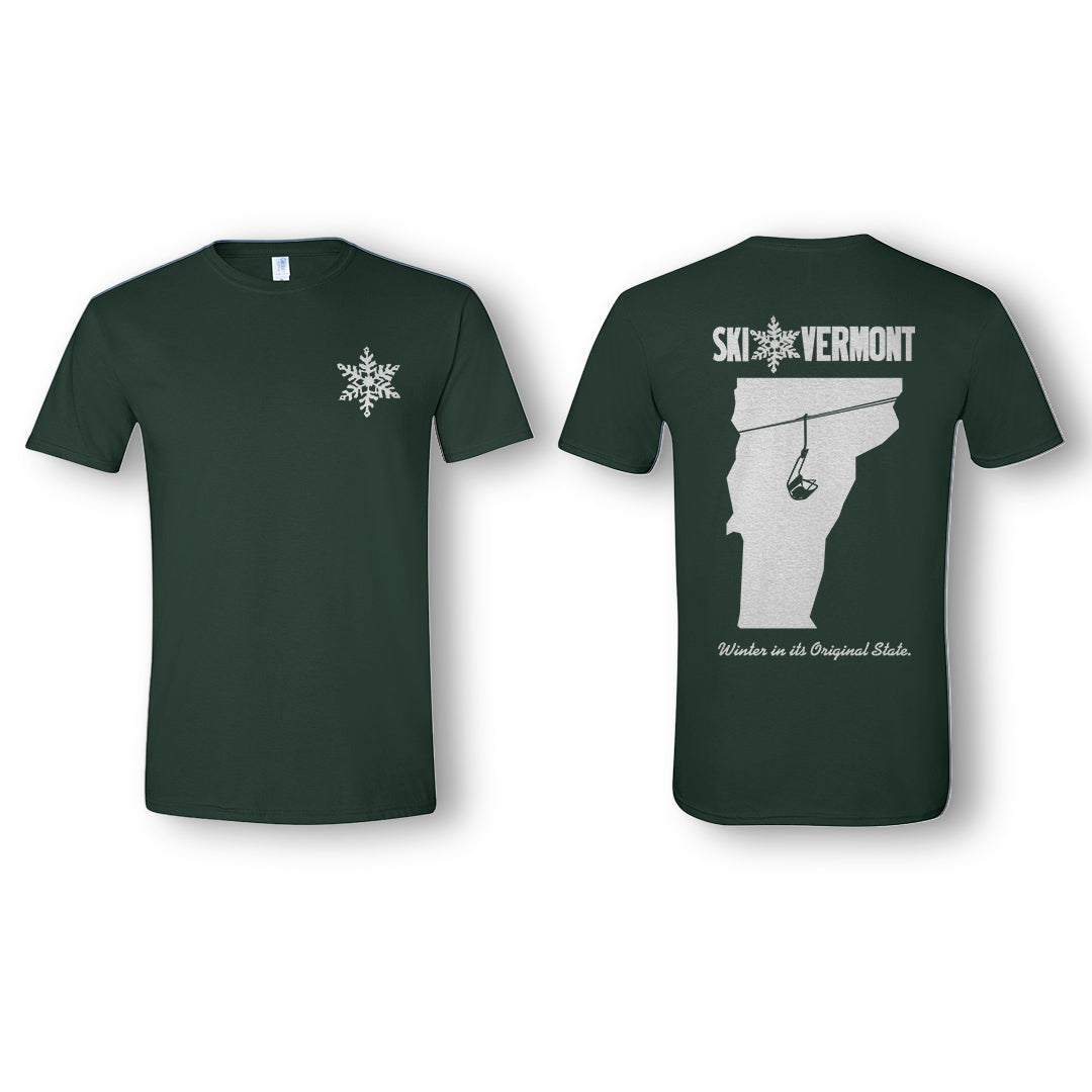 Front and back of a forest green “Ski Vermont” T-shirt. The front features a small white snowflake logo on the upper left chest. The back displays the Ski Vermont logo in white across the top, with a large outline of Vermont in light gray featuring a ski lift graphic. Below the design, white text reads “Winter in its Original State.”